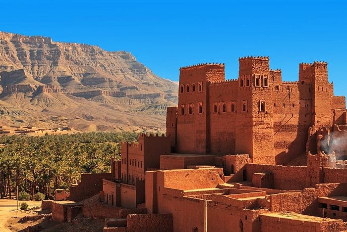 A mud-brick kasbah beside a palm grove below the mountains of southern Morocco
